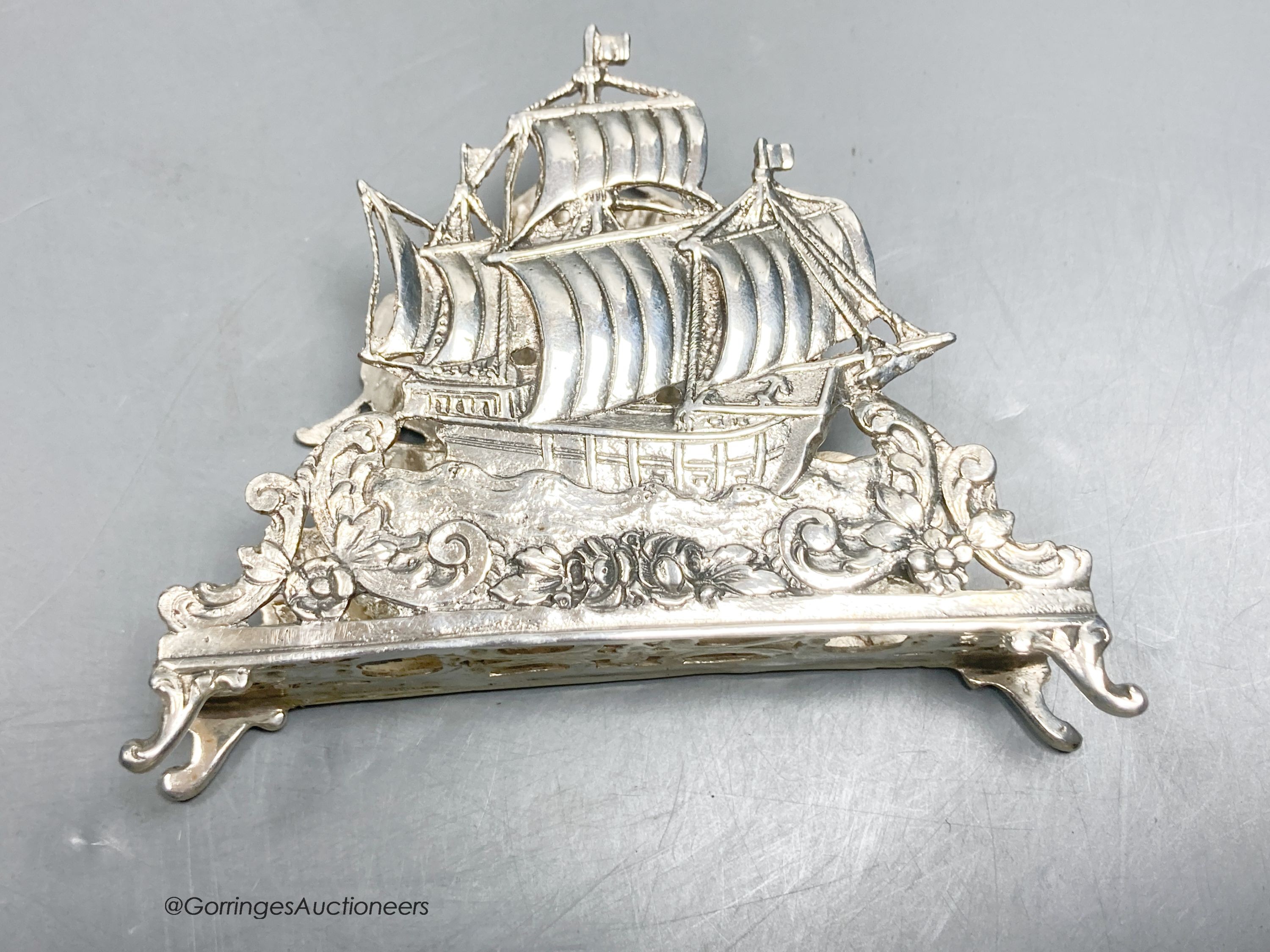 Two early 20th century German 800 standard pierced white metal letter racks, decorated with sailing ships, longest 13.8cm